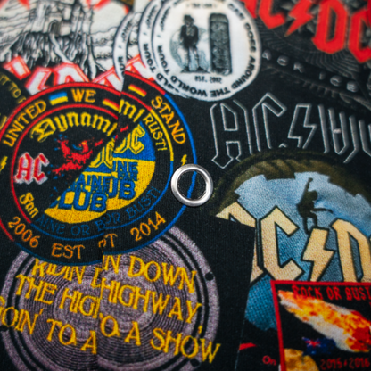 Close-up of a high-quality shirt from AC/DC. It is printed with many AC/DC patches. Not cheap merchandise, but high quality. 