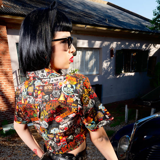 A woman is wearing a high-quality crop top from AC/DC. It is printed with lots of AC/DC patches. Not cheap merchandise, but high quality. 