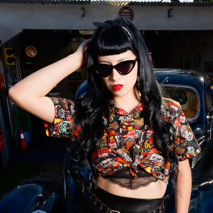 A woman is wearing a high-quality crop top from AC/DC. It is printed with lots of AC/DC patches. Not cheap merchandise, but high quality. 